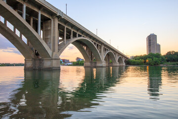 Fototapeta premium A bridge spans a river with a city in the background