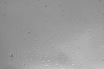 Rain drops on a window indicating gray and rainy day