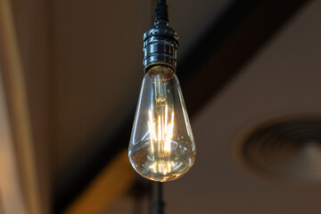 A vintage light bulb hanging from the ceiling.