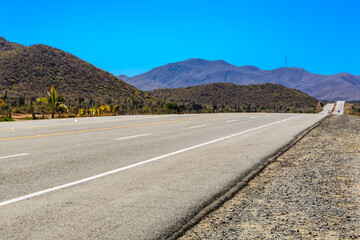 A long, empty road with a blue sky in the background