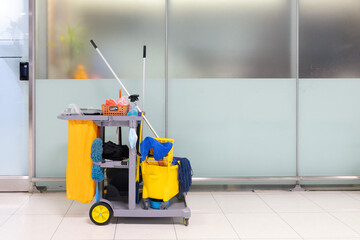 A cleaning cart with a yellow bucket and a blue mop