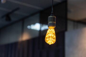 A LED light bulb hanging from a ceiling.