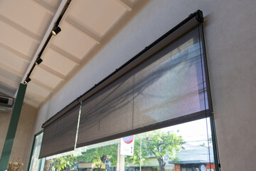 A window with a black screen that is open to the outside. black rolling blind curtain with window...
