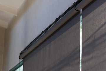 A window with a blind curtain that is black and grey
