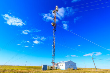 A tall tower with a white house in the background
