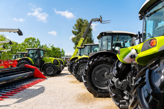 Agricultural machinery displayed at outdoor agri equipment dealership during summer.
