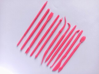 A row of pink fondant tools on a white background