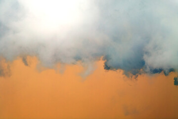 Orange sky with white clouds, beautifully colored, as background image.