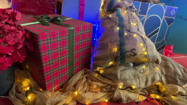 4k footage of interactive sparkling twinkle lights or icicle lights on a gift sack with gift box beside. Twinkle or icicle lights are often used for christmas light decoration.