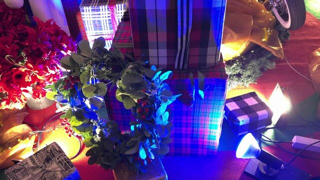 4k footage of christmas decoration of gift boxes, presents, candy cane, teddy bear, hampers, and other kids gift stuffs with wreathes and twinkle or icicle lights.