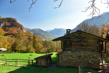 Old traditional wooden house in open air museum Ballenberg in autumn. View of the Alps. Municipality of Hofstetten bei Brienz, canton of Bern, Switzerland.
