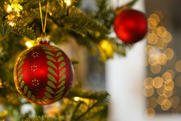Boladas de navidad colgadas en el árbol con luces de fondo
