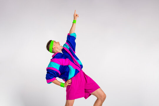 Energetic young man in retro sportswear striking a dynamic pose against a clean white background