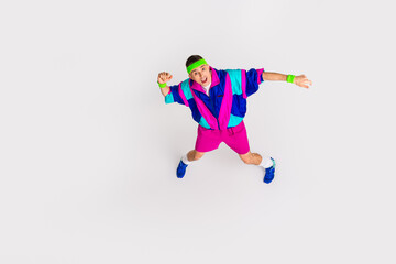 Obraz premium Young man in retro sportswear enjoying dynamic exercise with enthusiasm on white background