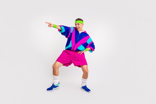 Energetic young man in colorful retro outfit pointing with confidence and enthusiasm