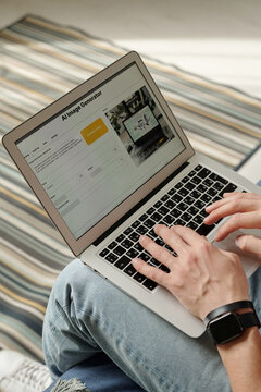 Hands of young unrecognizable creative man using AI image generator and pressing keys of laptop keypad