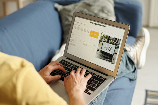 Hands of young unrecognizable female content creator using laptop with AI image generator on screen