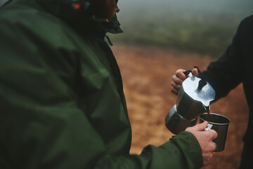 Hiking, people or hands with coffee on mountain for caffeine break, travel adventure or hobby for...