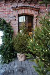 Fototapeta premium A solid brick building stands prominently with several decorated Christmas trees beautifully arranged in front of it, creating a festive and welcoming atmosphere during the holiday season