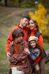 Family - mom, dad, daughter and son having fun in the autumn park