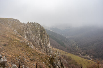 Foggy landscape at tureni gorges, a natural reserve with rugged limestone cliffs in transylvania, romania, on a chilly, misty day