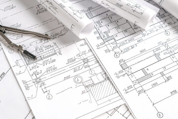 Close-up architect  designer working construction blueprints planning building project.detailed drawings planning tools desk modern workspace.professional project design architecture