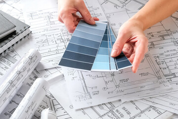 Close-up architect  designer working construction blueprints planning building project.detailed drawings planning tools desk modern workspace.professional project design architecture