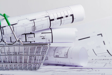 Construction plan in grocery basket. House design project. Miniature house in a basket..