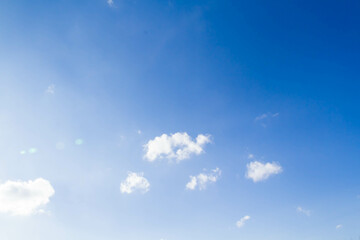 Fototapeta premium White airy beautiful clouds in a bright blue sky. Clear sunny weather. The concept of environmental safety and cleanliness..