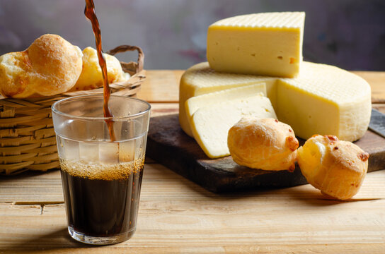 Cheese and cheese bread, a beautiful breakfast table with Brazilian delicacies and accessories on rustic wood, selective focus.