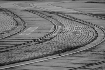 Tramway tracks on paved road bending in curves and over pedestrian walkway in Riga, Latvia