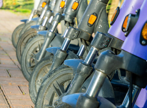 A close-up of the front of a row of electric scooters