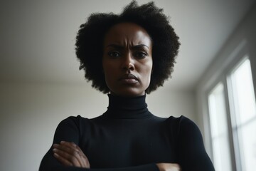 Obraz premium African female adult with afro hairstyle standing indoors in black turtleneck