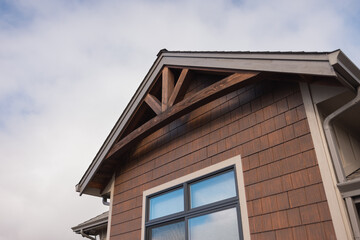 Wooden gable arch under a roof overhang on the side of a nice house