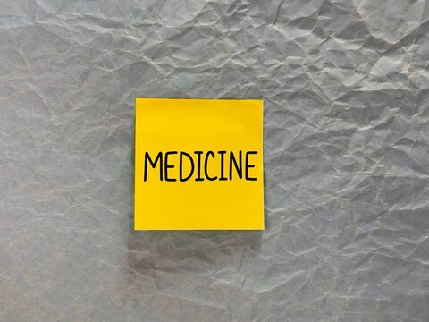 the inscription medicine. the hand is holding paper, and medicine is written on the paper. banner for advertising medical services. the inscription medicine on a paper background. 
