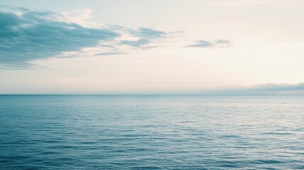 Obraz premium Tranquil sea with soft waves and calm skies.