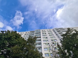 Fototapeta premium Blick auf eine Wohnungsfassade in Berlin Johannisthal, mit atmosphärischem Wolkenhimmel - für Themen rund um Wohnen in Berlin, Mieten, Gentrifizierund und mehr