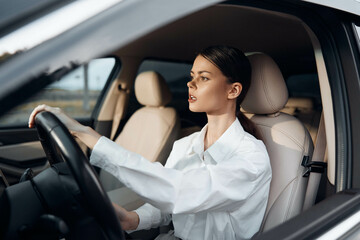 Car, driver, woman, steering wheel, looking at camera a woman is seated in the driver's seat of a...