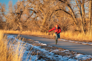 senior male with backpack is inline skating on a paved bike trail along Poudre River in Colorado,...