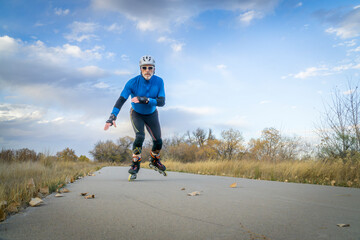 Senior athletic male  inline skating on the Poudre RIver Trail in Colorado, late fall scenery
