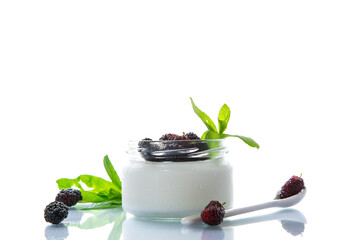 homemade sweet yogurt in a jar with black mulberries isolated on white background
