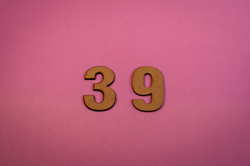 Number 39 in wood on a pink background