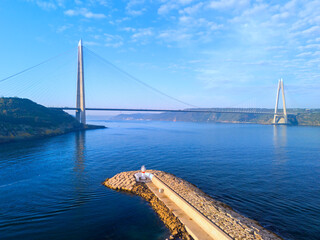 Obraz premium Yavuz Sultan Selim Bridge Istanbul Stunning Cable-Stayed Bridge Over Waterway with Coastal Defense Structures. A breathtaking view of a modern cable-stayed bridge spanning a body of water, likely