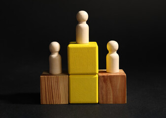Winner. Wooden figures on cubes against black background