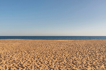 Sand dunes and horizon of the sea on sunny day.