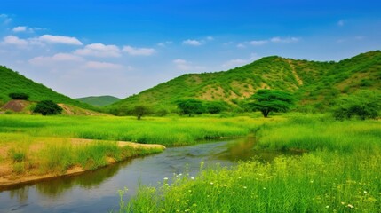 Lush green hills and a serene river under a bright blue sky.