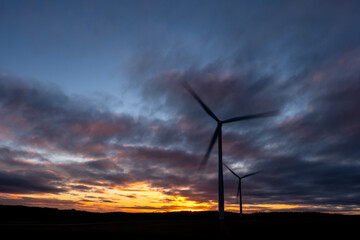 Obraz premium Spinning wind turbines at sunrise