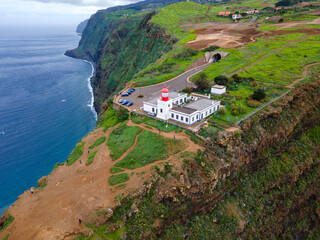 
 farol da Ponta do Pargo, Ilha da Madeira. A foto destaca o farol ic&ocirc;nico localizado no topo de uma fal&eacute;sia imponente.