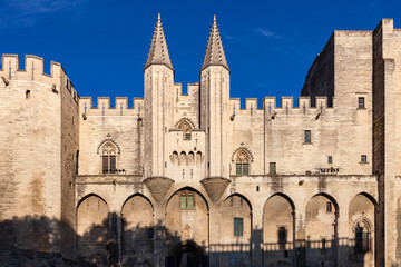 Stone facade of the "Palais Neuf" under warm late afternoon light,  "Palais des Papes", Palace of the Popes, Avignon, Vaucluse, Provence, France