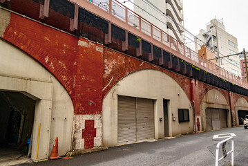 Historic Koyanagi Bridge Viaduct with Red Brick Arches, Now Repurposed as Storage Facilities, Under Elevated Train Line (Tokyo, Japan ‐ December 2024)